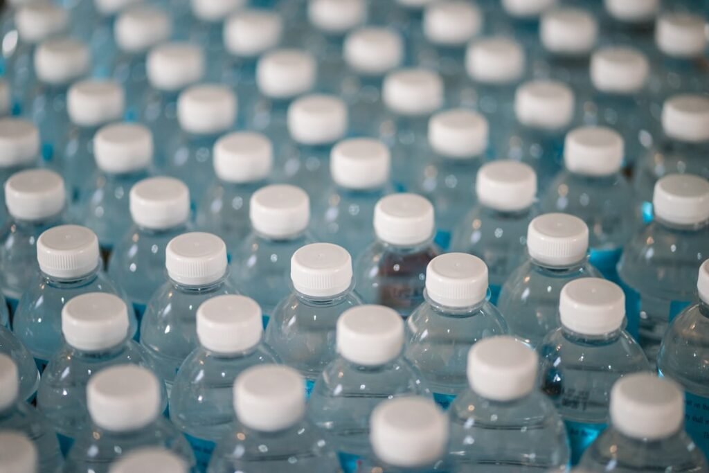 Rows of factory-sealed water bottles with white caps, illustrating consistent quality and tamper-evident packaging