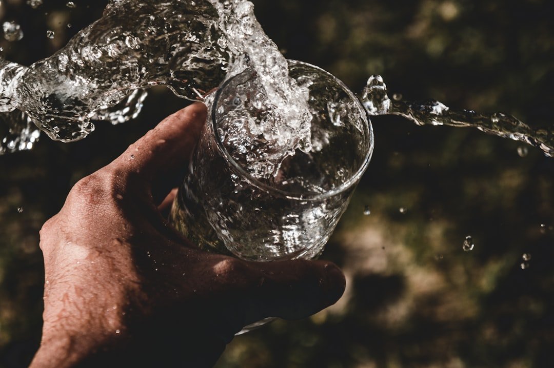 Crystal clear mineral water being poured into a glass, representing pure and safe drinking water delivery in Multan