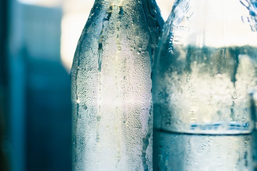 Water bottles sweating with condensation from heat, illustrating the risk of storing bottles in high temperatures