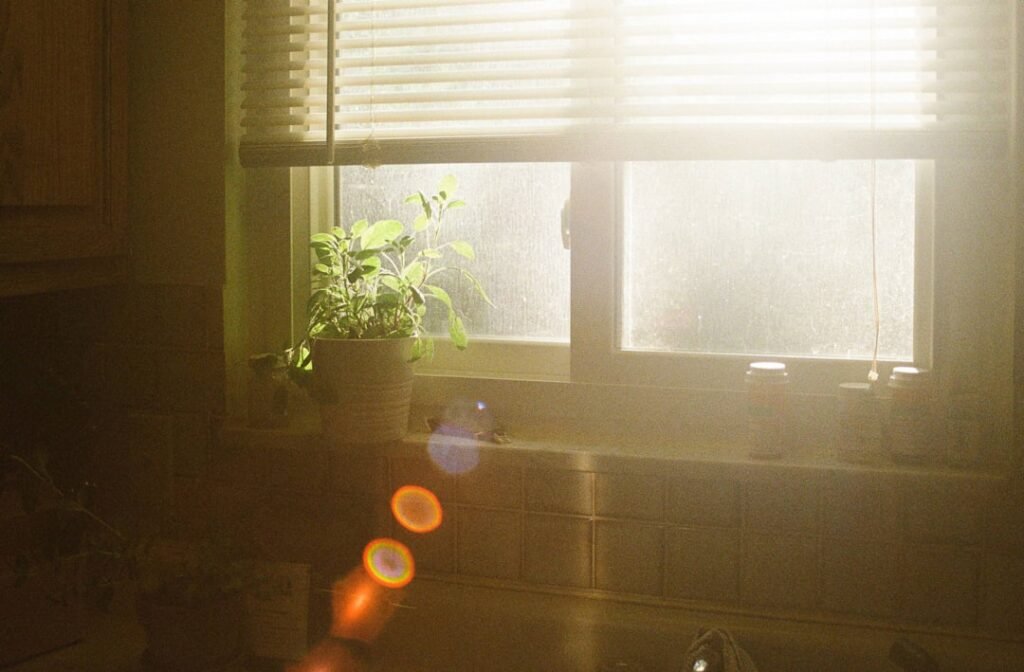 Intense sunlight blazing through kitchen window blinds illustrating the heat risk for stored water bottles in Multan summers