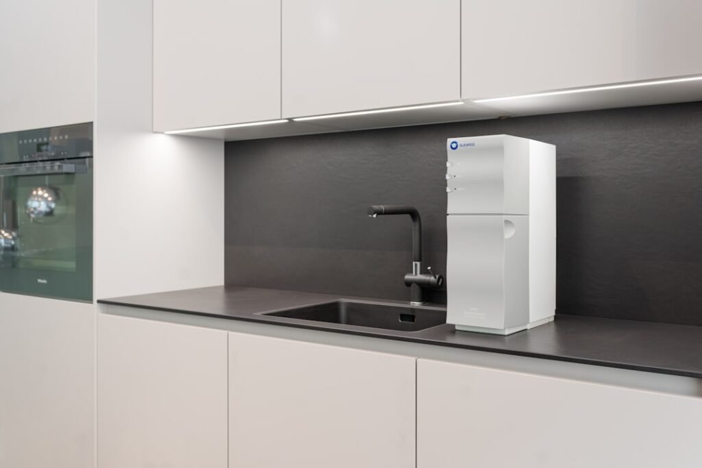 A modern home water purification unit installed under a kitchen counter, representing RO filtration systems compared to sealed mineral water for pregnancy safety.